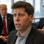 Primer plano de un hombre con expresión seria, con dos personas desenfocadas en el fondo en un entorno corporativo.