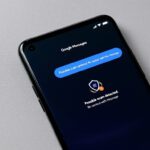 Pantalla de un smartphone con Google Messages mostrando una alerta de detección de estafas IA, indicando protección contra fraudes en mensajes.