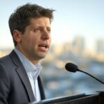 Sam Altman, CEO de OpenAI, hablando sobre el futuro de la inteligencia artificial durante una conferencia, con fondo urbano desenfocado.
