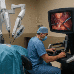 Cirujano operando mediante un sistema de cirugía robótica Da Vinci, controlando brazos robóticos para un procedimiento mínimamente invasivo, ilustrando los avances en cirugía robótica.
